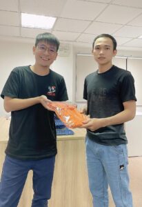Anh Tiến - CEO tặng áo công ty cho bạn Tưởng (bên phải)